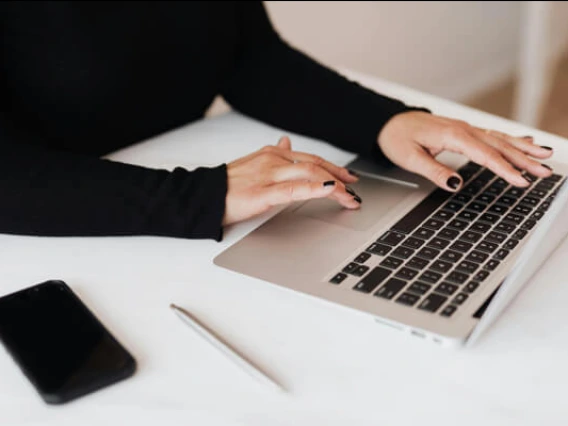 Young woman typing on a laptop